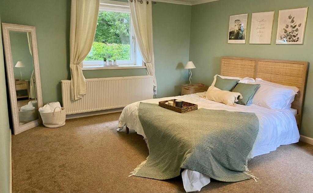 Un dormitorio con una cama grande y una ventana en Johnstonebridge Cottage en Johnstonebridge