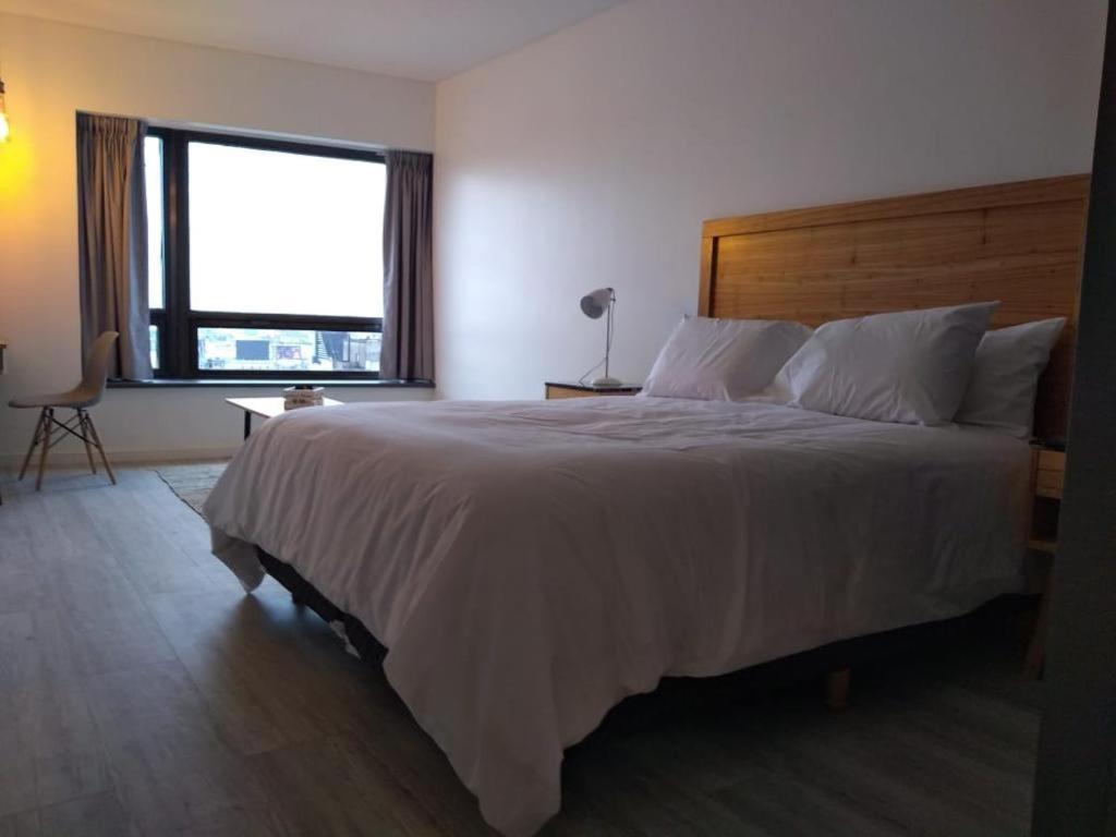 1 dormitorio con 1 cama grande y ventana grande en Obelisco Sunset Apart 820 en Buenos Aires