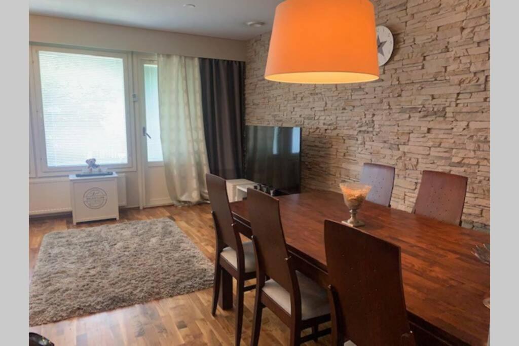 a dining room with a wooden table and chairs at Luxus house with Sauna Nearby Airport in Vantaa