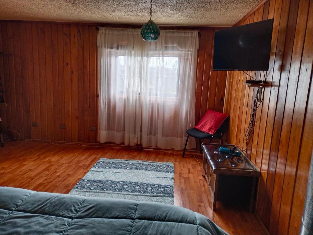 a living room with a couch and a television at lotus shared-house in Puerto Montt