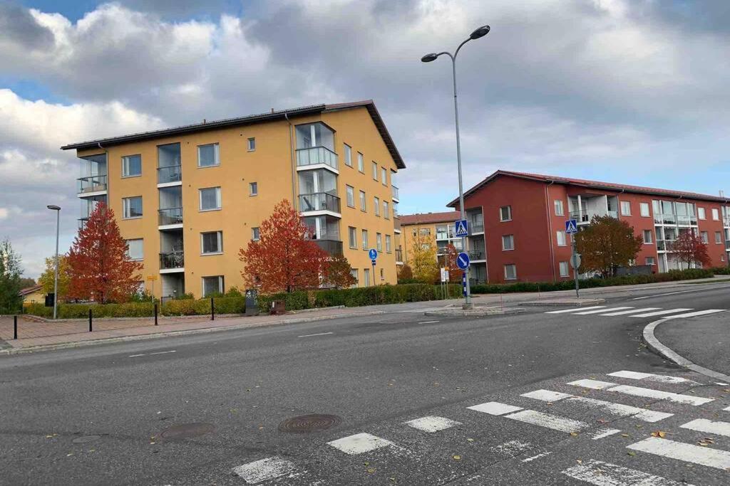una calle vacía con edificios al lado de la carretera en Modern Apartment with Sauna Nearby Airport, en Vantaa