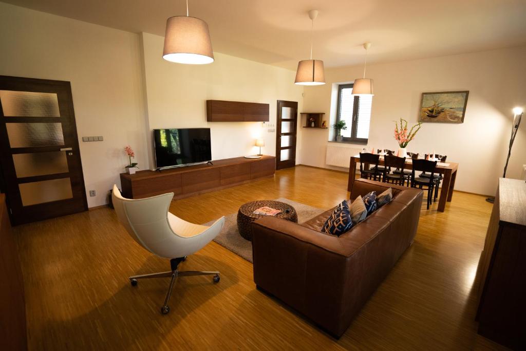 a living room with a couch and a chair at Black Field Apartment in Brno