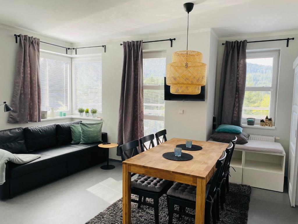 salon ze stołem i kanapą w obiekcie Apartment Klínovec SUN - garážové parkování w mieście Loučná pod Klínovcem