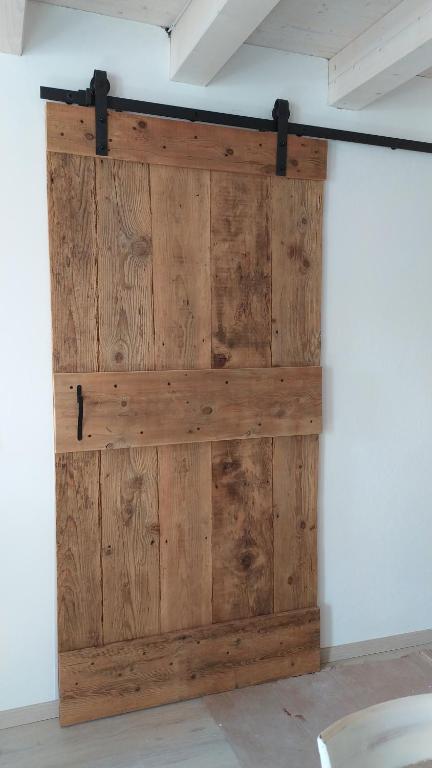 a wooden door on a wall in a room at Casetta dei nonni in Pescantina