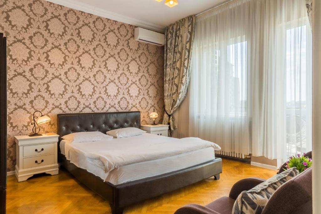 ブカレストにあるDeluxe Cișmigiu Parkのベッドルーム(大型ベッド1台、ソファ付)