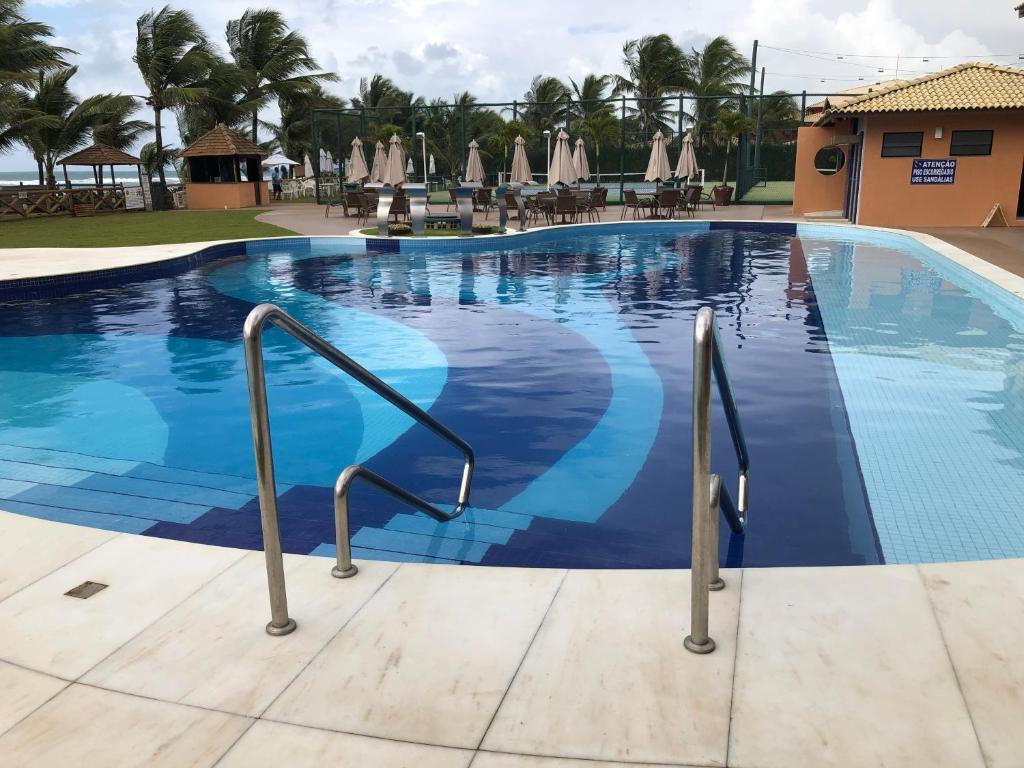 a swimming pool at a resort at 2 Suítes, Guarajuba, piscina frente mar in Guarajuba