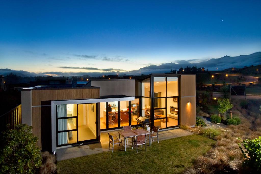a view of a house with a table and chairs at The Fairways Luxury Accommodation Kaikoura in Kaikoura