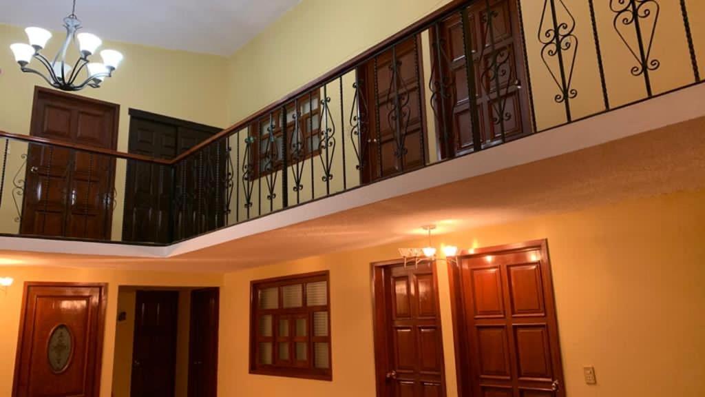 uma escada num quarto com portas de madeira em Hotel Santa Fe em Chignahuapan