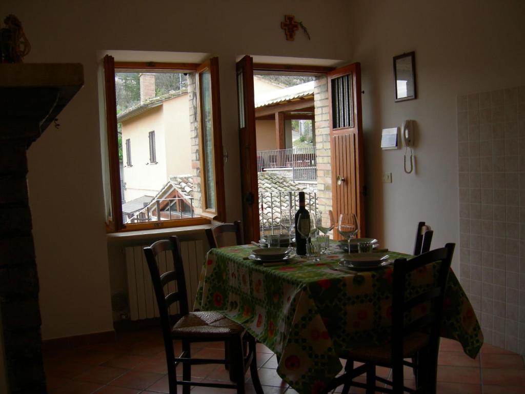 a dining room with a table with a bottle of wine at Casa Vacanze Fortini Mario in Piano Delle Pieve