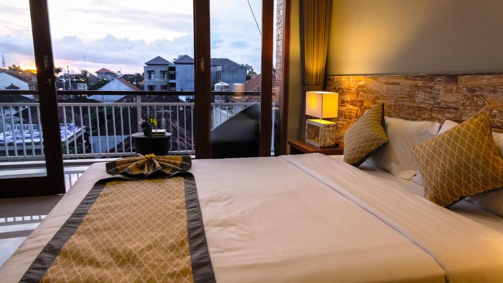 sypialnia z dużym łóżkiem i balkonem w obiekcie Kubu De Uma w mieście Seminyak