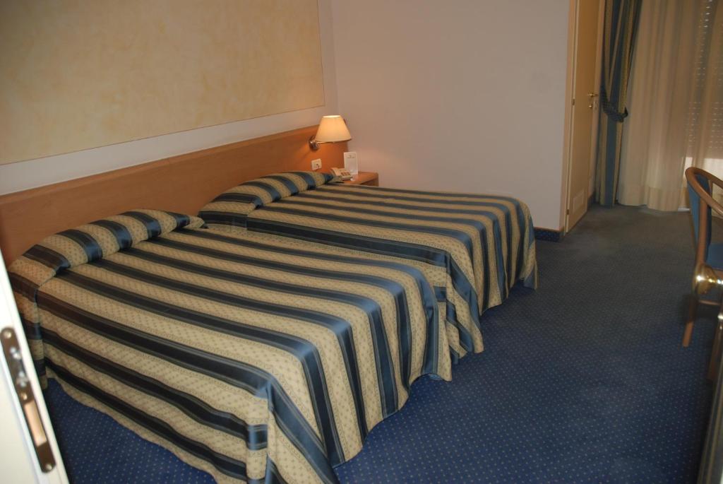 A bed or beds in a room at Hotel Continental Brescia