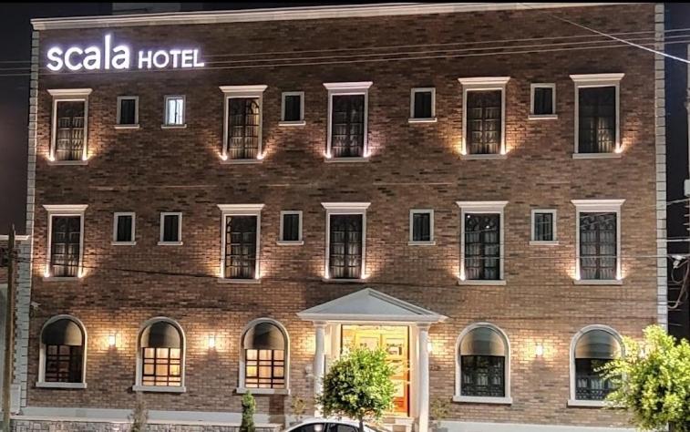 un grand bâtiment en briques avec un panneau d'hôtel dans l'établissement Scala Hotel, à Lagos de Moreno