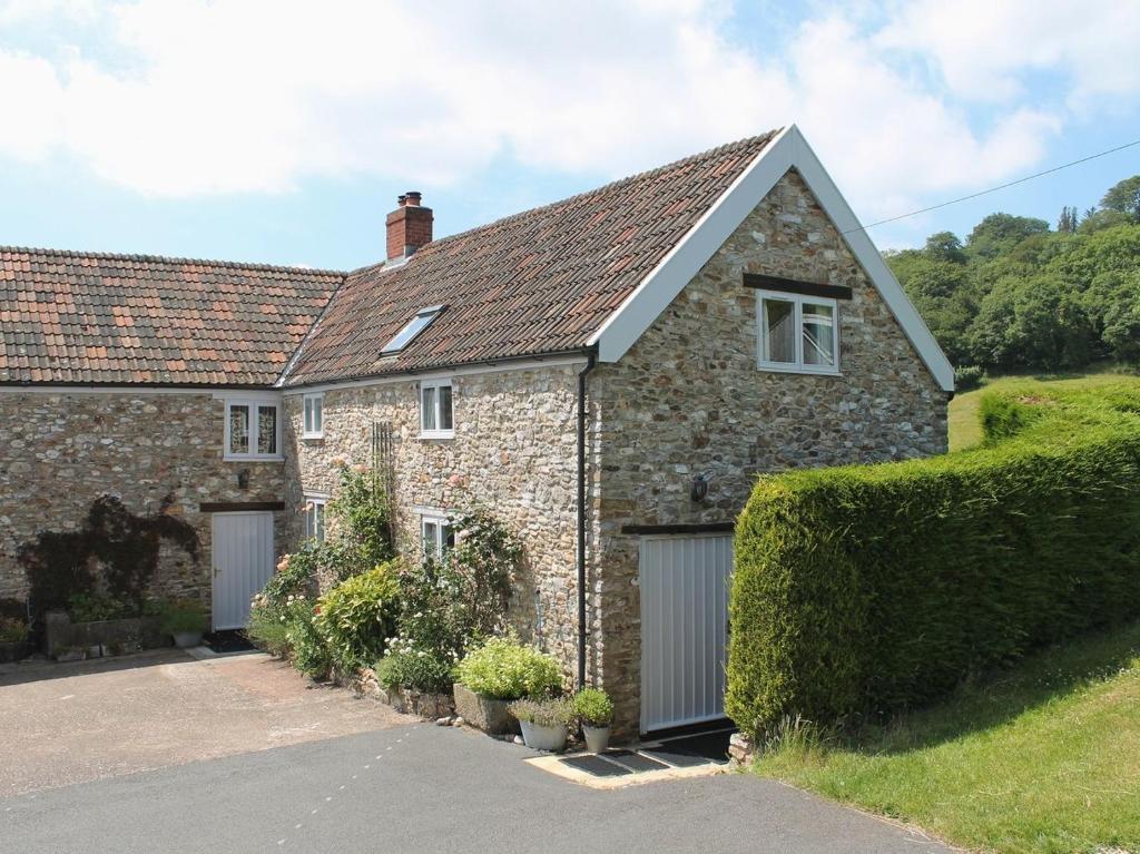 an old stone house with a garage at Whitcombe Cottage in Honiton