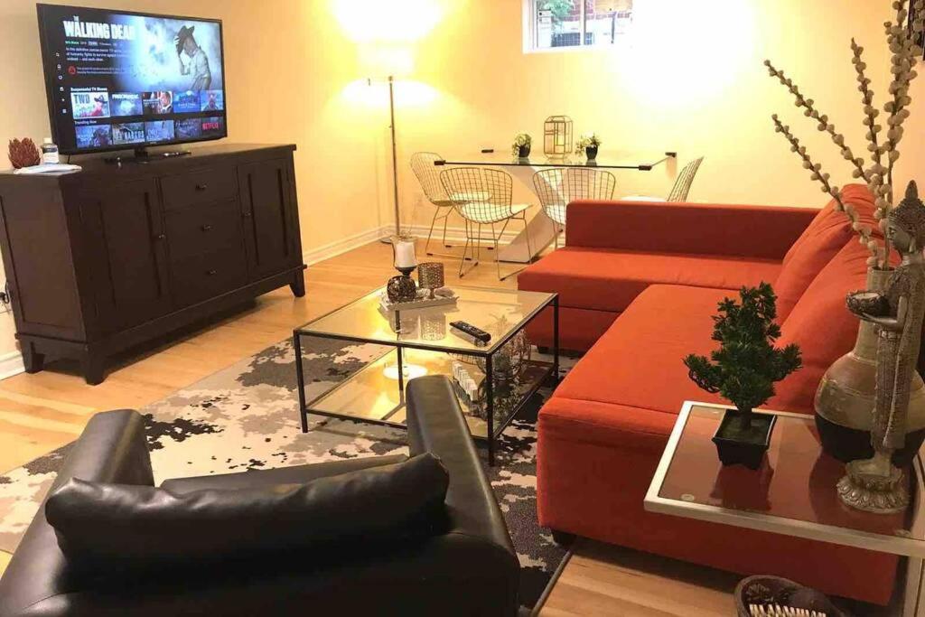 een woonkamer met rode banken en een tv bij Tastefully decorated spacious apartment Burlington in Burlington