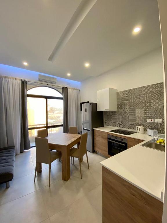 a kitchen with a table and chairs in a room at Diamonds Luxury apartment - Julia in Marsalforn