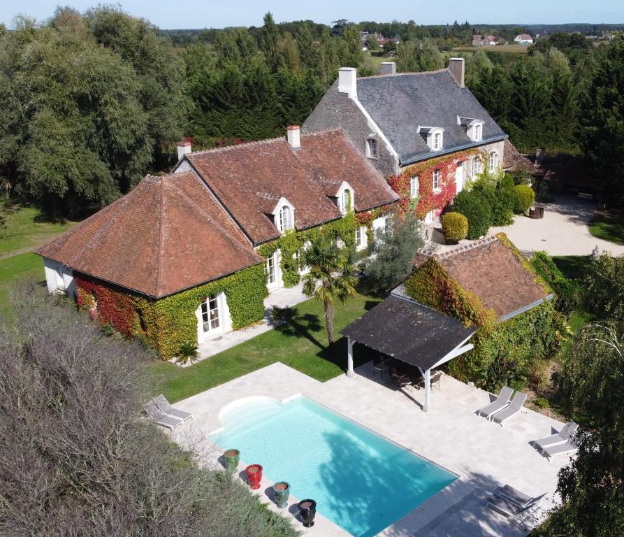 eine Luftansicht eines Hauses mit Pool in der Unterkunft Domaine de la Blonnerie in Feings