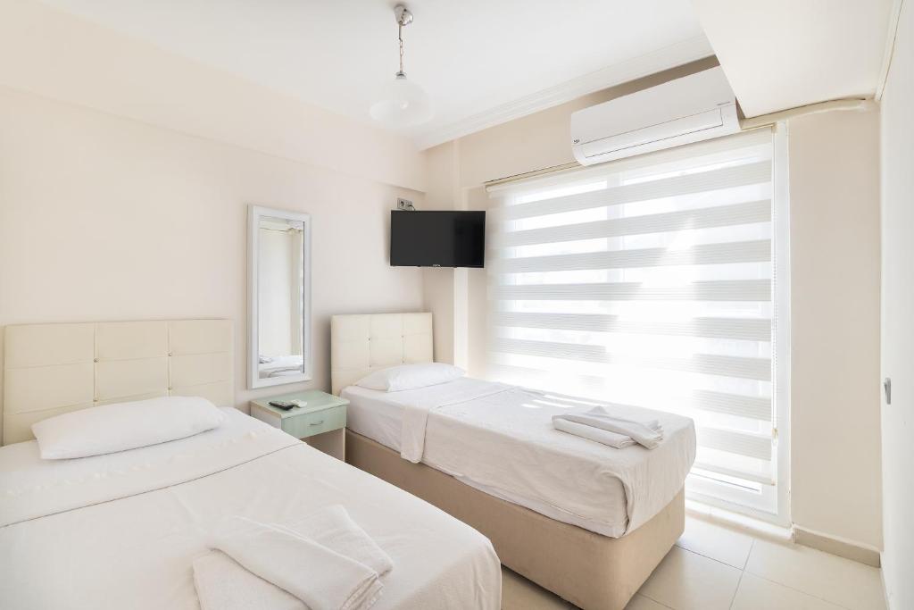 2 camas en una habitación blanca con ventana en Apartments Near to City Center and Beach en Marmaris