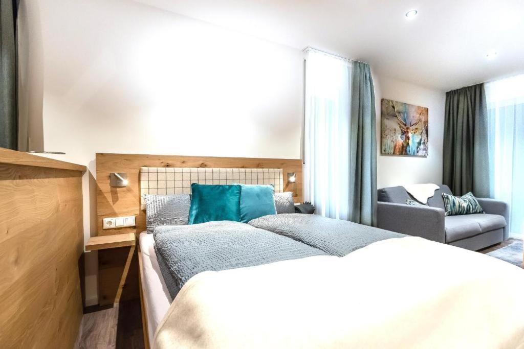 une chambre d'hôtel avec deux lits et un canapé dans l'établissement REINERS Quartier - relaxed living, à Bruckberg