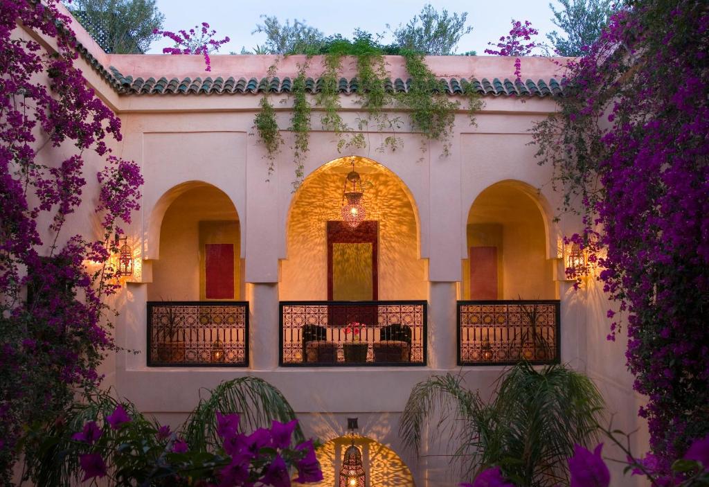 a courtyard of a house with purple flowers at Riad Meriem in Marrakesh