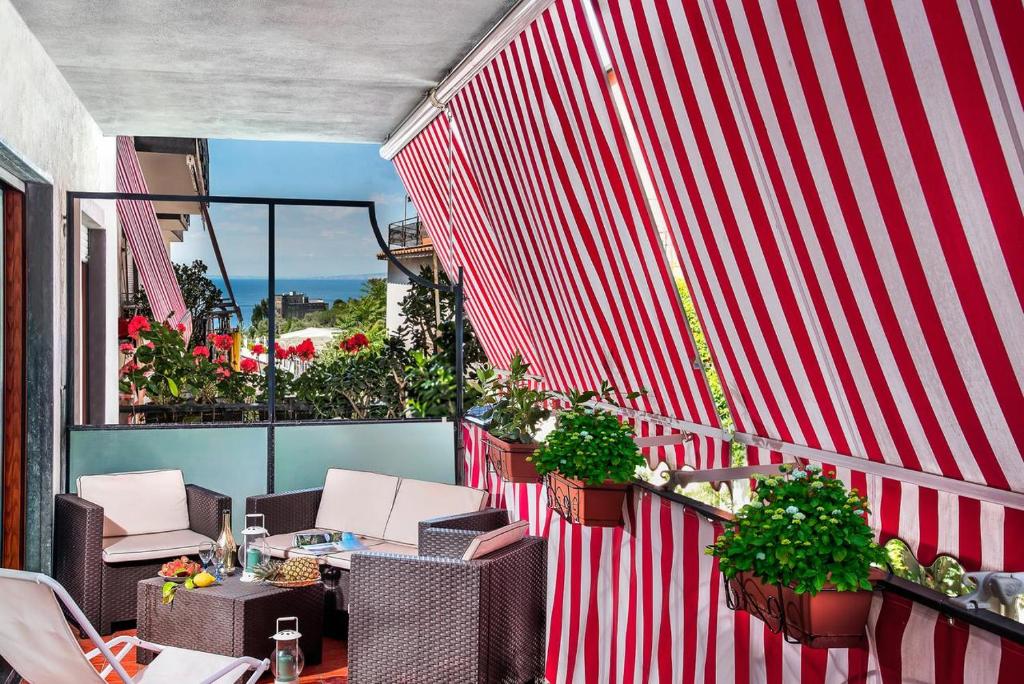 een balkon met stoelen en tafels en een rode muur bij At Home Sorrento in Sorrento