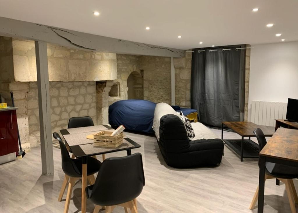 sala de estar con cama, mesa y sillas en Appartement en plein centre ville d'Argentan, en Argentan