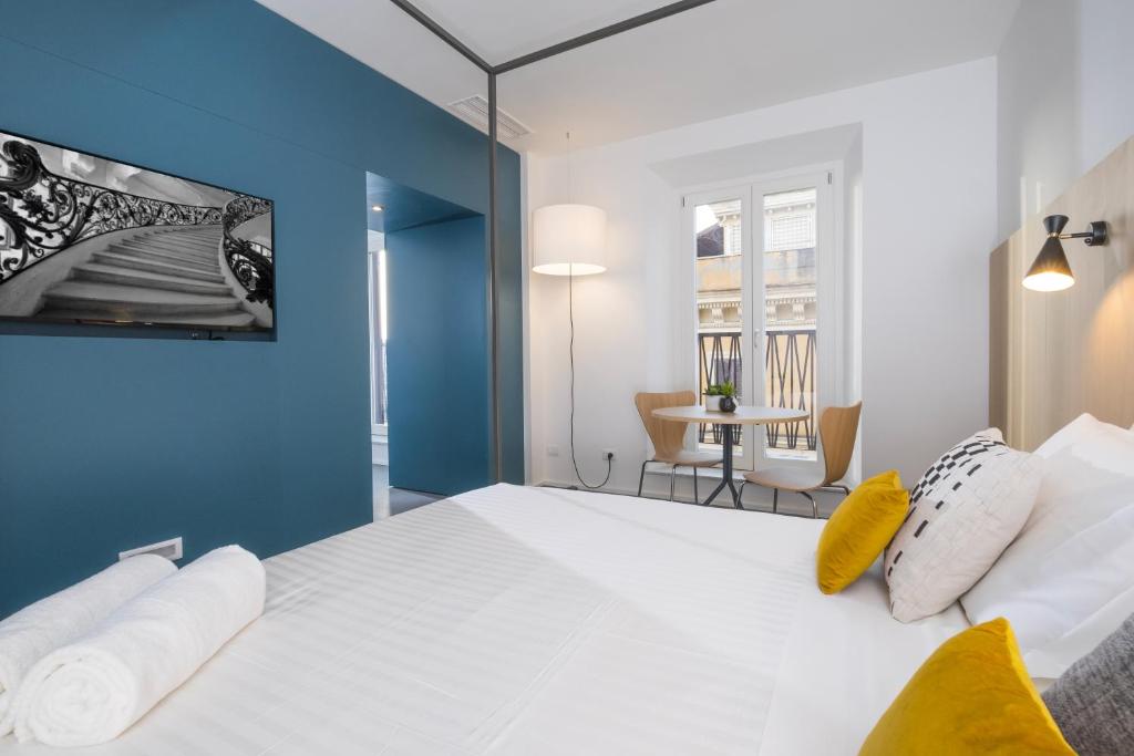 a bedroom with a large white bed with a blue wall at Camplus Hotel Roma Centro in Rome