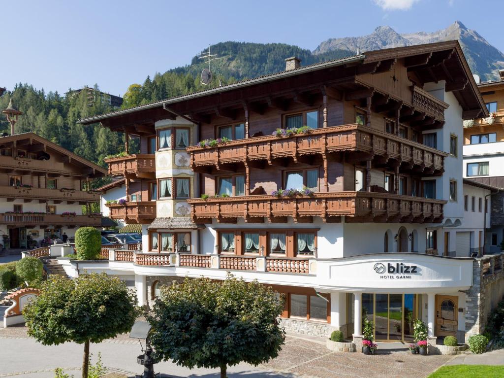 a large building with balconies on the side of it at Hotel BLIZZ in Finkenberg