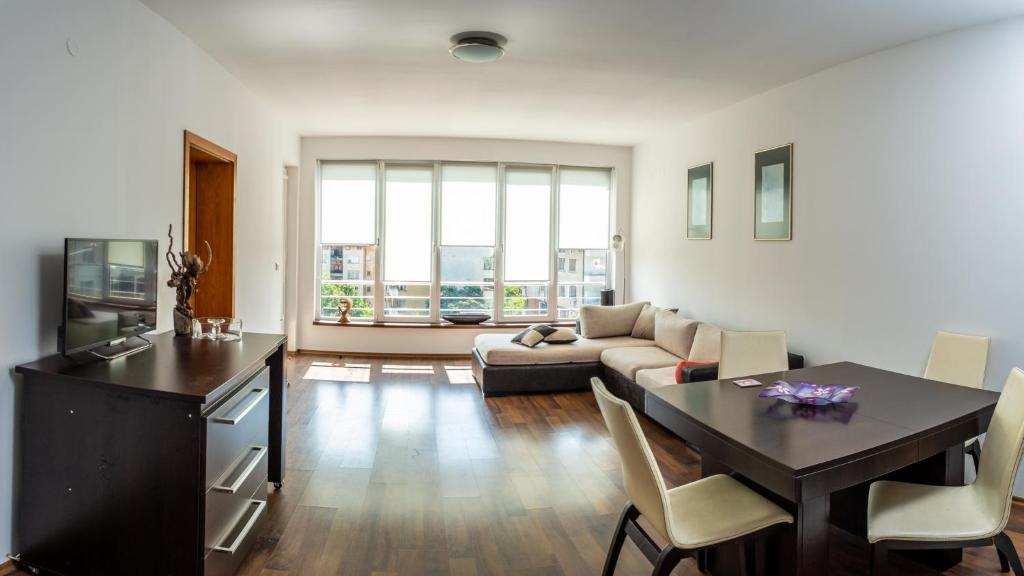 a living room with a table and a couch at Central Apartment Mountain View in Karlovo