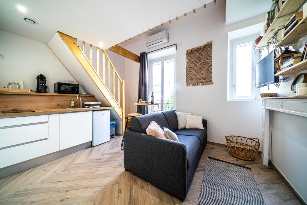 a living room with a couch and a kitchen at Le Boheme - Rent4night Grenoble in Grenoble