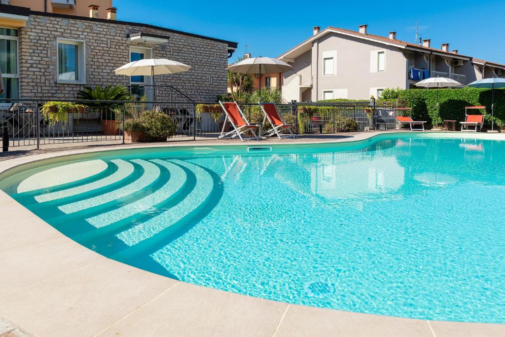 a large swimming pool with blue water at Residence Campana in Bardolino