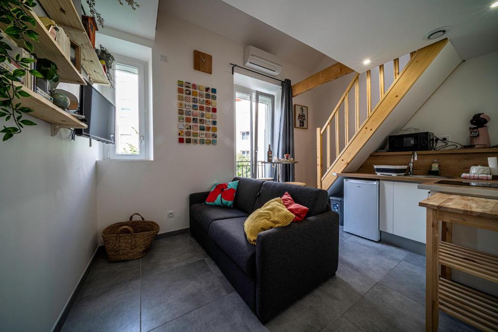 a living room with a couch and a kitchen at Le Pop'Art - Rent4night Grenoble in Grenoble
