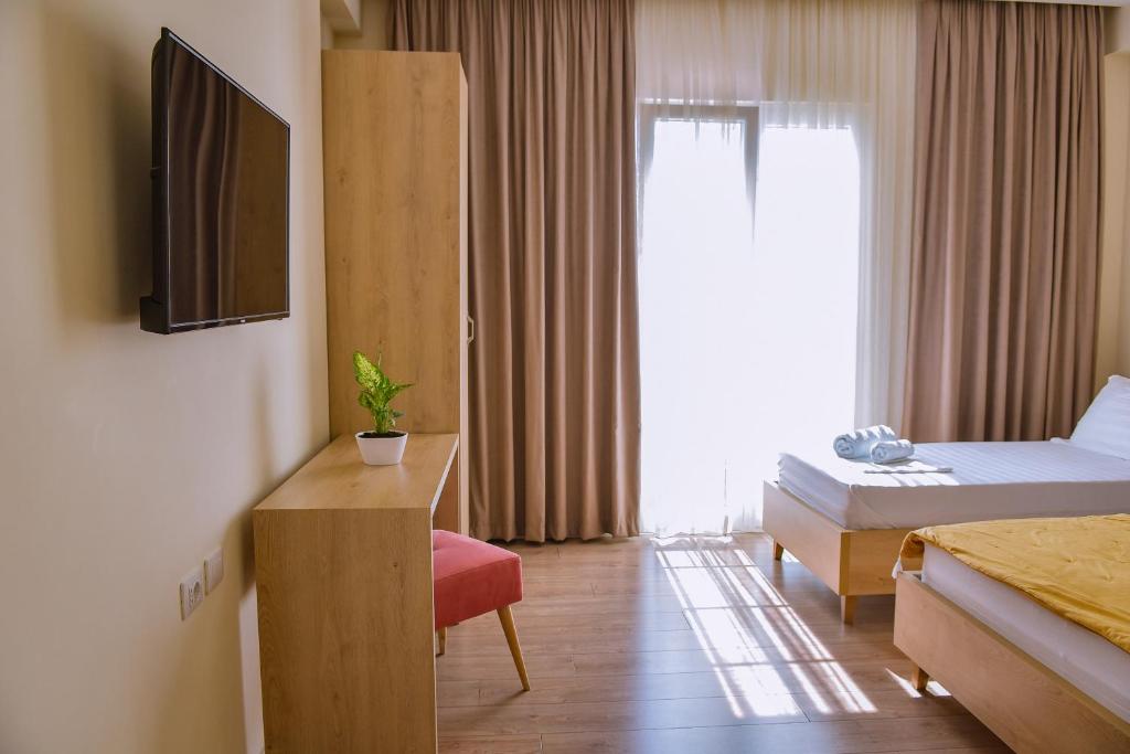 a hotel room with a bed and a television at Airport Garden Hotel in Rinas