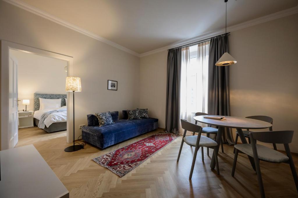 uma sala de estar com um sofá azul e uma mesa em Hotel Bruneck Design-Apartments em Brunico