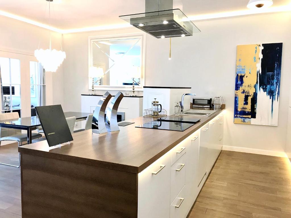 a kitchen with white cabinets and a large island at MONDRIAN Luxury Suites UNESCO Old Town in Warsaw