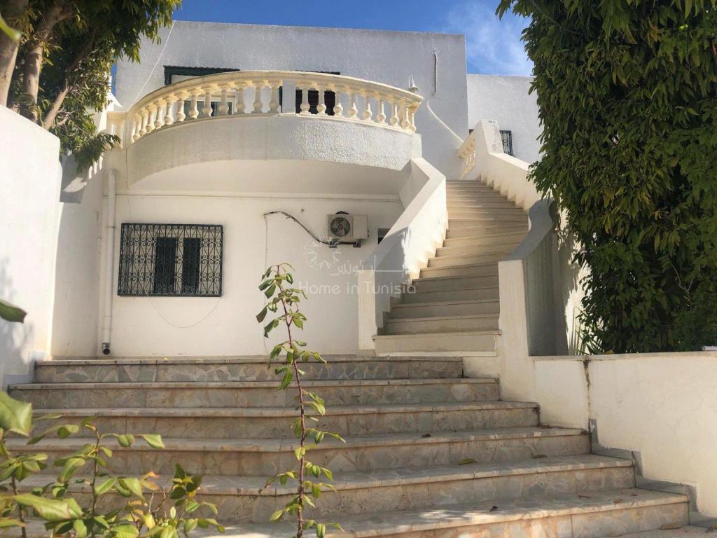 a white house with stairs in front of it at Spacieuse Villa S+3 meublé à kantaoui in Sousse