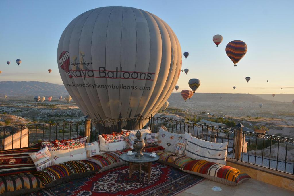 a group of hot air balloons flying over a balcony at Hotel Lalesaray in Uçhisar