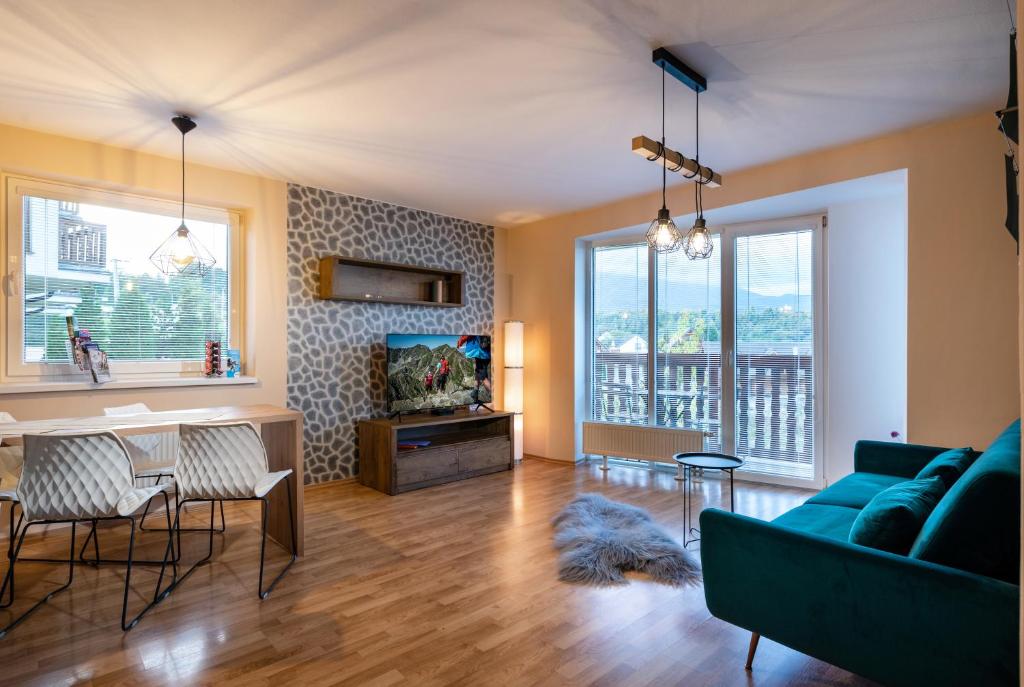 ein Wohnzimmer mit einem blauen Sofa und einem Tisch in der Unterkunft Apartmany Tilia in Nová Lesná