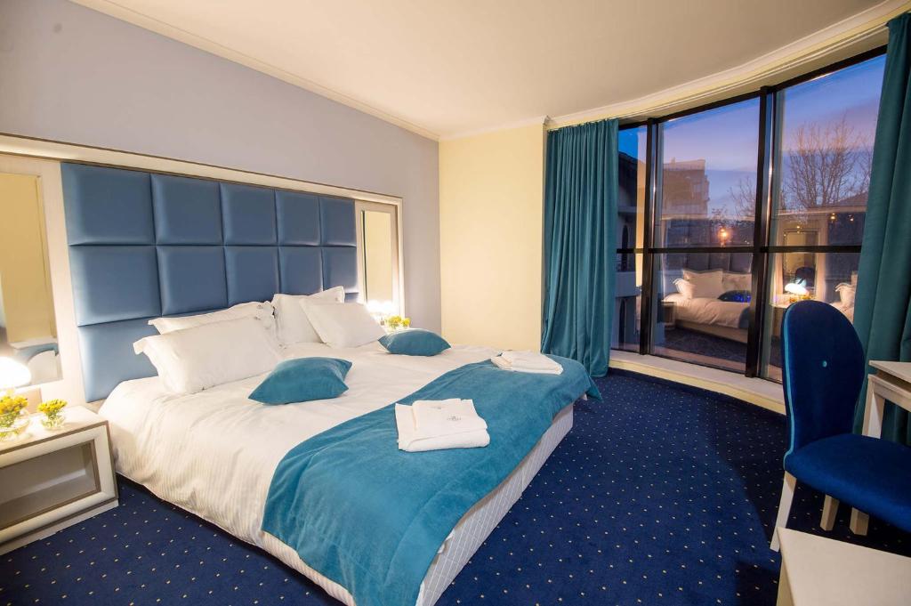 パザルジクにあるHotel Forumの大きなベッドと大きな窓が備わるホテルルームです。