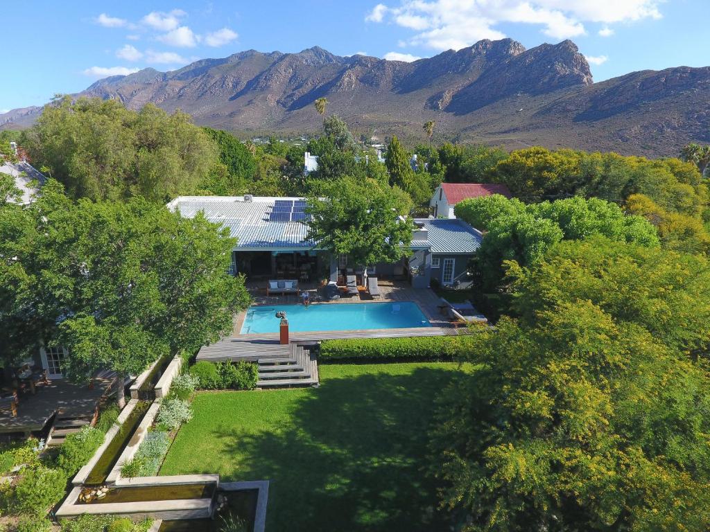 a house with a swimming pool and mountains in the background at In Abundance Guest House in Montagu