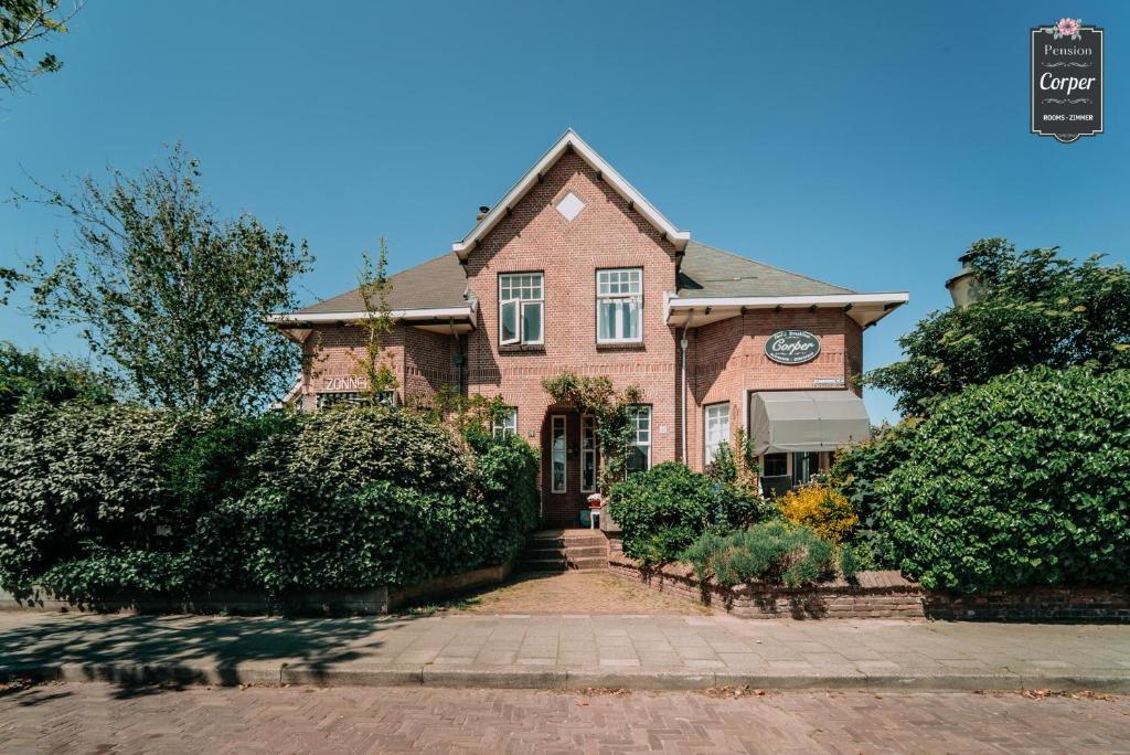 a brown brick house with a clock on it at Pension Corper in Zandvoort