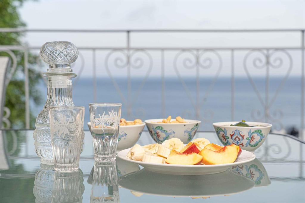 a glass table with two bowls of fruit on a plate at Tzortzi's Family Apartments in Kaloi Limenes