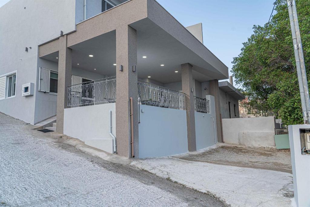 a house with a white garage door on a street at Tzortzi's Family Apartments in Kaloi Limenes