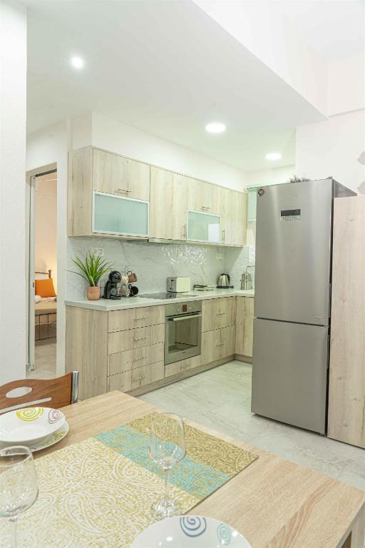 a kitchen with a stainless steel refrigerator and a table at Tzortzi's Family Apartments in Kaloi Limenes