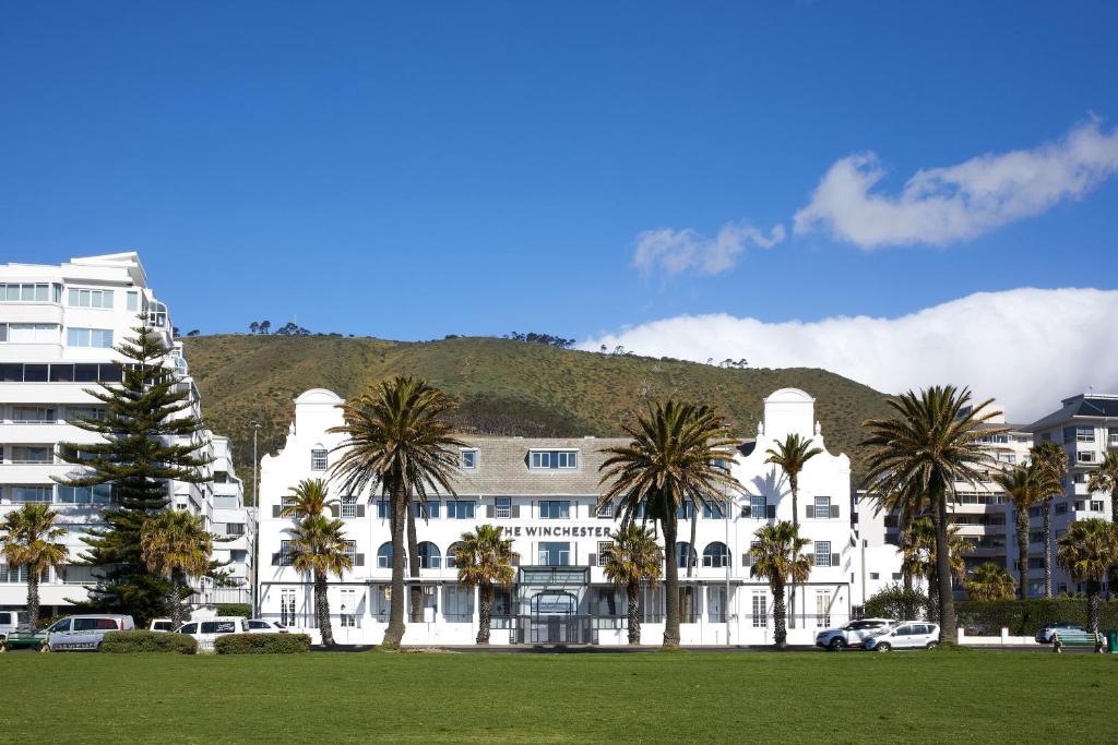 um grande edifício branco com palmeiras em frente em The Winchester Hotel by NEWMARK em Cidade do Cabo