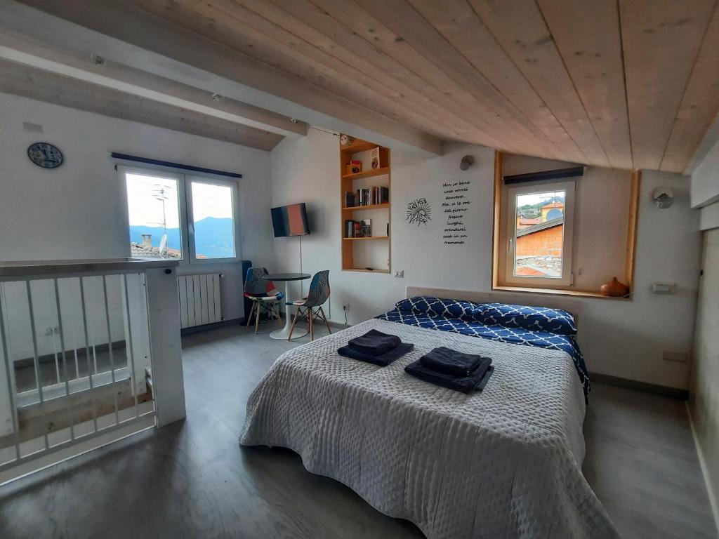 a bedroom with a bed with two black towels on it at Casa Tilde Guest House in Cunardo