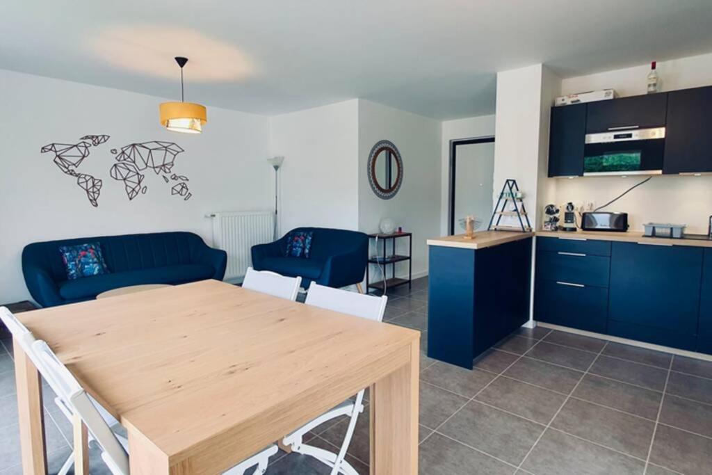 cocina y sala de estar con mesa de madera en Le Laudon 3 étoiles - Familiale, Moderne, Tout équipé, Proche Lac et commodités en Saint-Jorioz