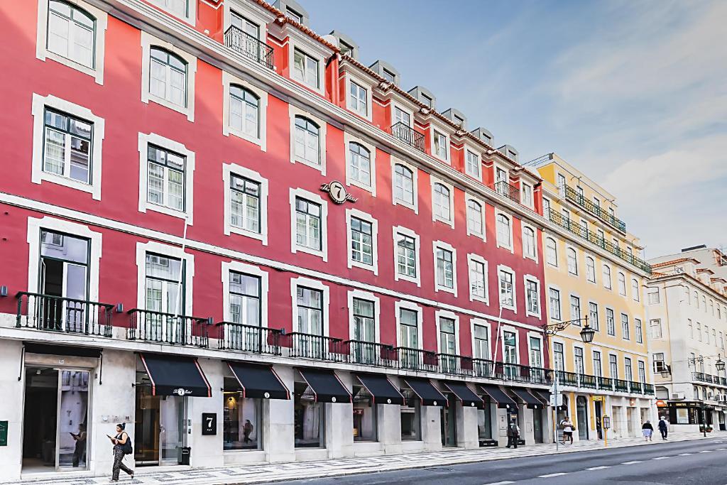 a large red building on the side of a street at The 7 Hotel, Suites, Studios & Apartments in Lisbon