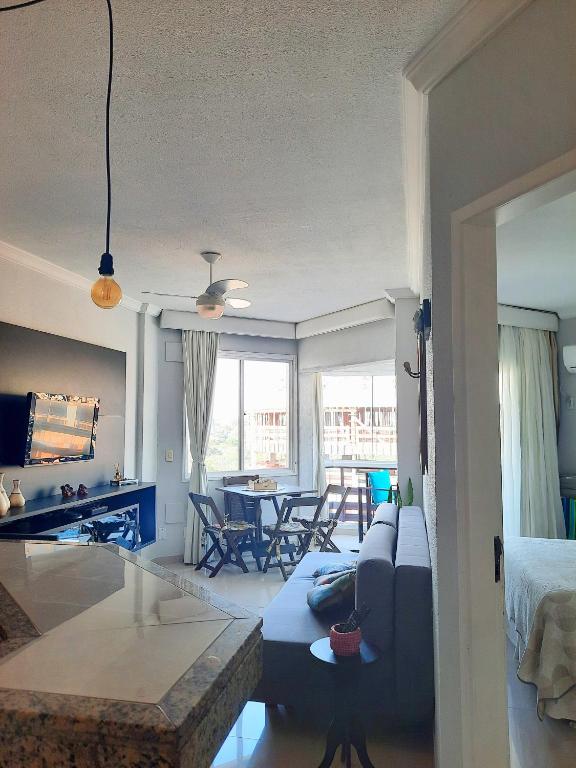 a living room with a blue couch and a table at Apartamento Ingleses Norte in Florianópolis