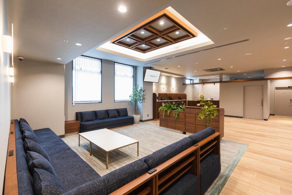 a waiting room with a couch and a table at Sotetsu Fresa Inn Hiroshima in Hiroshima