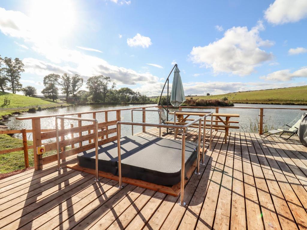 a bed on the deck of a boat on a river at Douglas Cabin in Worcester